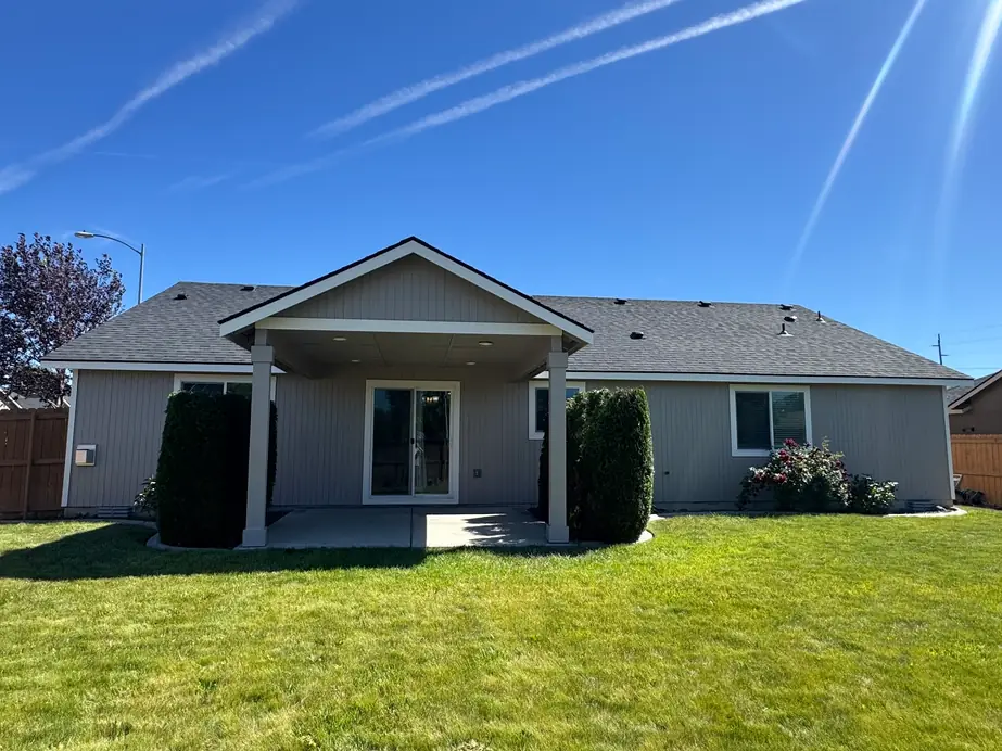 Single-story grey ranch home with a covered porch, freshly painted